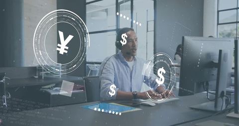 Asian man wearing headset at workstation with holographic currency, fintech interface