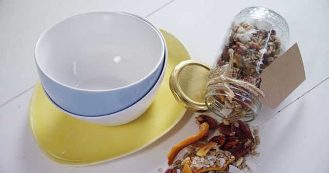 Spilled Jar of Granola with Empty Blue and White Bowl on Yellow Plate - Download Free Stock Images Pikwizard.com