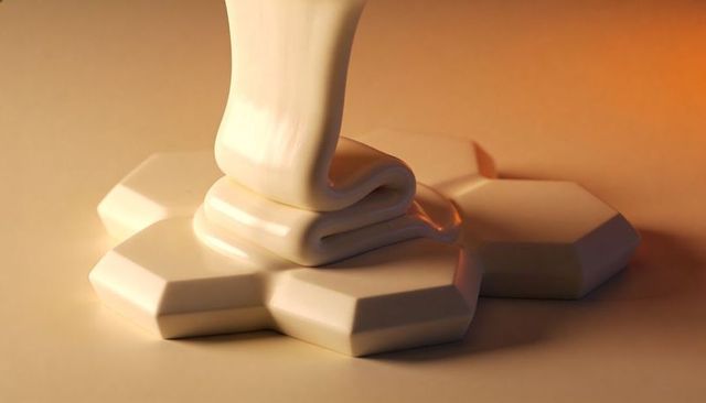 Creamy white glaze pouring over silky glossy hexagonal tiles with warm golden reflections
