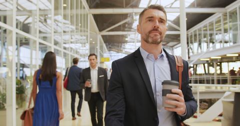Businessman with Coffee in Modern Conference Foyer