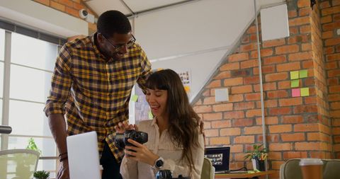 Creative graphic designers reviewing digital camera images together