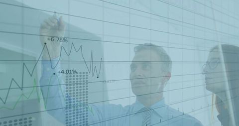 Businessman Analyzing Data on Transparent Board in Modern Office