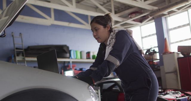 Female mechanic using laptop and inspecting the car at a car service station - Download Free Stock Photos Pikwizard.com
