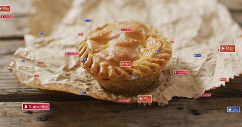 Golden hand pie resting on crumpled parchment with social media play subscribe like badges