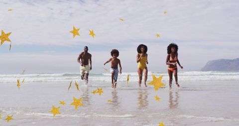Family running and splashing through surf at sunny beach with gold star elements