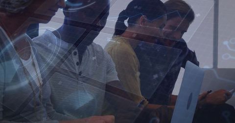 Diverse team collaborating on laptops and smartphones in backlit modern coworking workspace