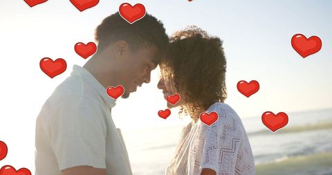 Romantic Couple Embracing on Sunny Beach with Hearts Overlay