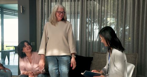 Mature group engaging in therapeutic discussion session with counselor