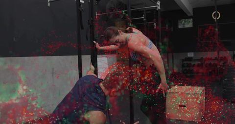 Female athlete balancing on gym rings with spotter and plyo box, colorful speckled effect
