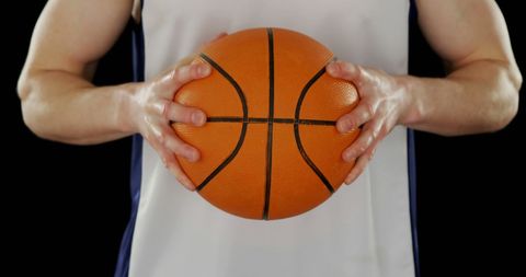 Basketball Player Holding Ball Against Black Background - Download Free Stock Images Pikwizard.com