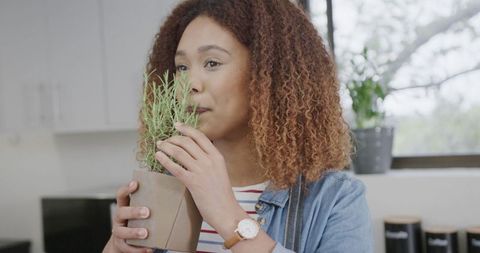 Young Woman Enjoying Fresh Herbs in Modern Kitchen