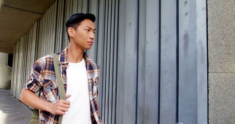 Young Man Leaning Against Metal Wall in Contemplative Pose - Download Free Stock Images Pikwizard.com