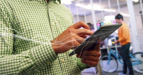 Professional Analyzing Data on Tablet in Modern Office Workspace