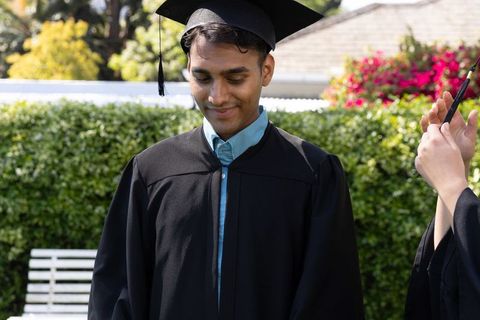 Graduate Student Smiling During Outdoor Graduation Ceremony