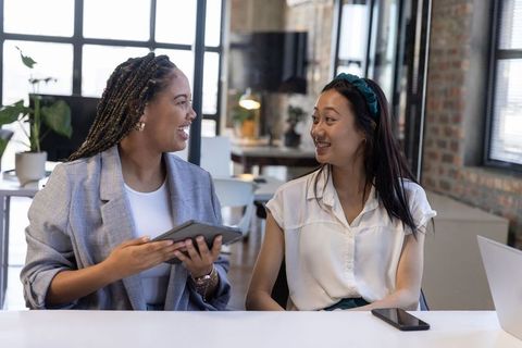 Diverse Female Coworkers Collaborating at Modern Office Desk