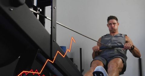 Caucasian man on rowing machine with data visualization