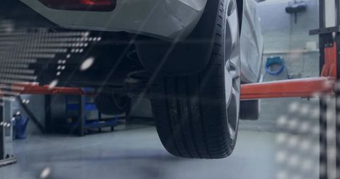 Rear Passenger Alloy Wheel on Lift Close-up Showing Tire Tread, Rim and Suspension