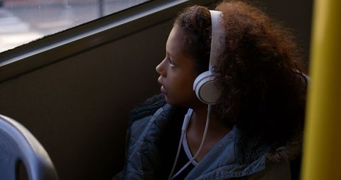 Thoughtful Girl with Headphones on Public Bus