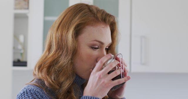 Young woman enjoying hot beverage in bright kitchen - Download Free Stock Images Pikwizard.com