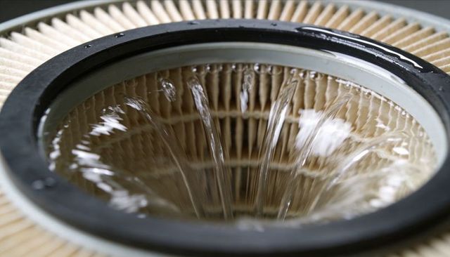 Water pouring into pleated cartridge filter with rubber gasket macro splash
