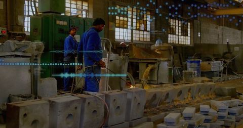 Industrial workers operating gas torch in factory