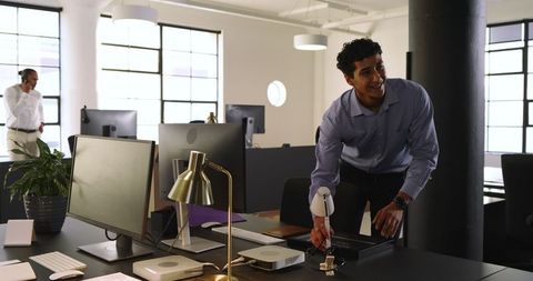 Young professional organizing desk in modern office for work
