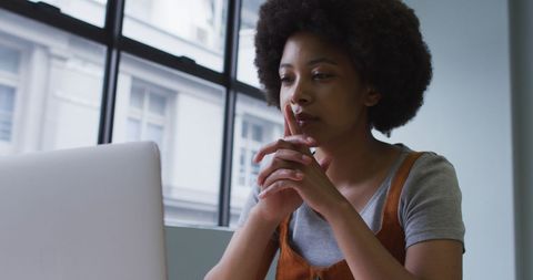 Focused Businesswoman Using Laptop in Modern Office Workspace