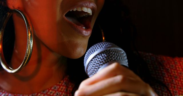 African American woman singing passionately into a microphone, with copy space. Her expression and the close-up of the mic capture the intensity of a live music performance.