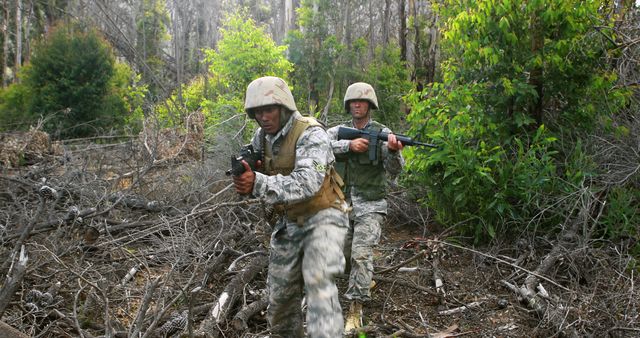 This depicts military soldiers on patrol in a dense forest. They are wearing camouflage uniforms and helmets, holding firearms, and moving through the rough terrain. It can be used in articles about military training, tactical operations, teamwork, and the challenges faced by soldiers in diverse environments.