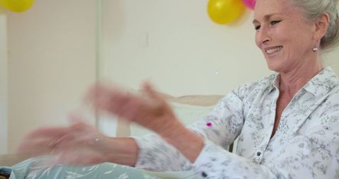 Senior Woman Joyfully Tossing Confetti at Celebration Home Decor