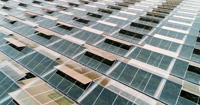 A pattern of reflective glass panels covers the facade of a modern building, creating an abstract and geometric aesthetic. The design showcases contemporary architecture's focus on sustainability and visual impact.