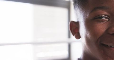 Close-Up of Smiling Teen with Blurred Window Background