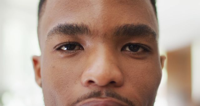 Close up of face of african american man opening eyes. Lifestyle, living, spending free time at home concept.