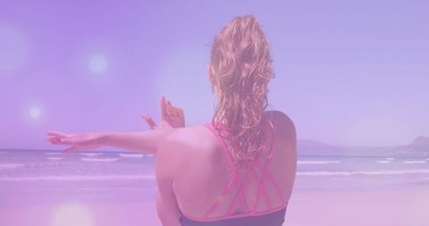 Woman Practicing Yoga on Sunny Beach with Serene View