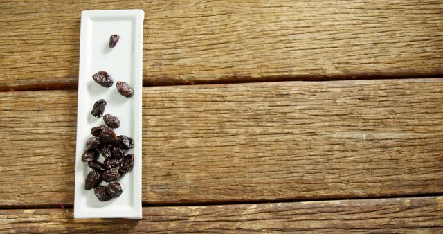 Healthy Black Raisins in White Ceramic Dish on Rustic Wooden Surface - Download Free Stock Images Pikwizard.com