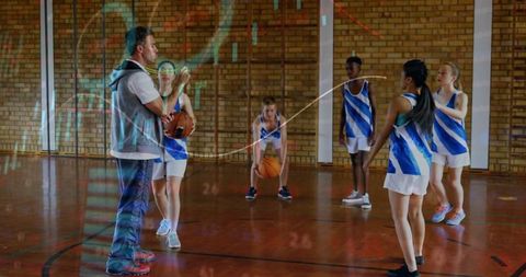 Basketball coach training youth team in school gym