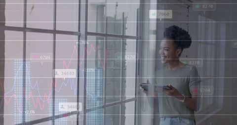 Businesswoman Analyzing Financial Data on Tablet by Office Window