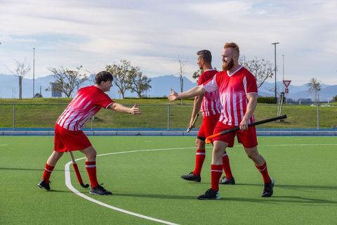 Male Field Hockey Teammates Celebrating Achievement with High Fives