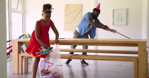 Family Joyfully Cleaning Up After Birthday Celebration