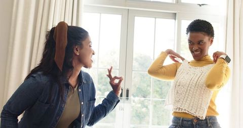 Diverse Female Friends Sharing Fashion Advice Indoors