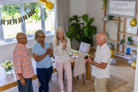 Senior Friends Celebrating Retirement with Gift Inside Home