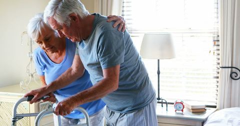 Senior Woman Assisting Elderly Man with Mobility Aid at Home - Download Free Stock Images Pikwizard.com