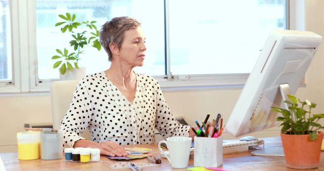 Caucasian businesswoman using computer working in office with copy space. Business, office, work and professionals concept, unaltered.