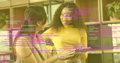 Female Developers Collaborating on Tablet with Code Overlay