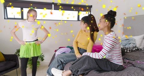 Girls celebrating dress-up night wearing green tutu skirt, friends cheering