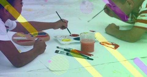 Two boys painting together at school art table, collaborative creativity and color play