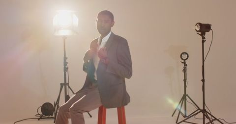 Professional man in suit sitting in well-lit studio
