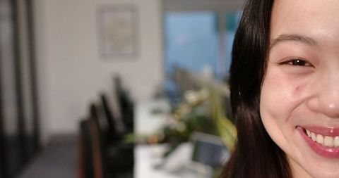 Business Woman Smiling in Bright Modern Office with Greenery