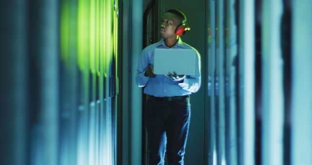 IT Technician Inspecting Server Room Wearing Headphones Holding Laptop - Download Free Stock Images Pikwizard.com