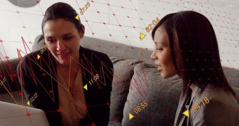 Businesswomen Collaborating on Laptop with Overlayed Analytics Graphs and Time Markers